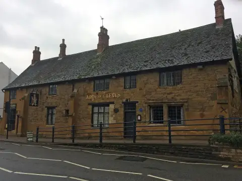 Long ironstone building with a stone-slate roof and its name in gold letters across the front