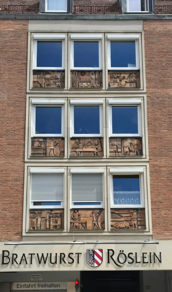 Brick front with nine ceramic relief panels of butchers and drinkers under its windows