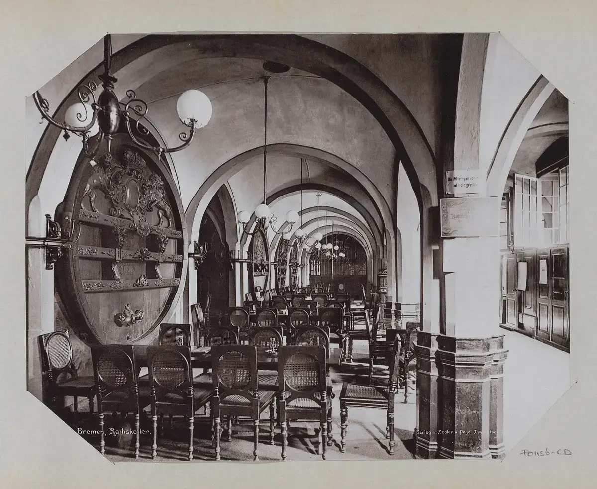 Photograph of the vaulted Ratskeller in 1895, long tables down the arcade and a great carved wine tun in the foreground