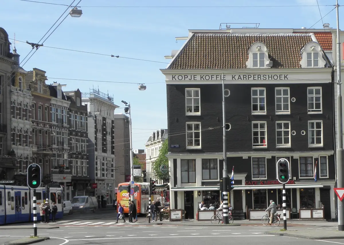 Dark corner building lettered Kopje Koffie Karpershoek above three floors, café awning below