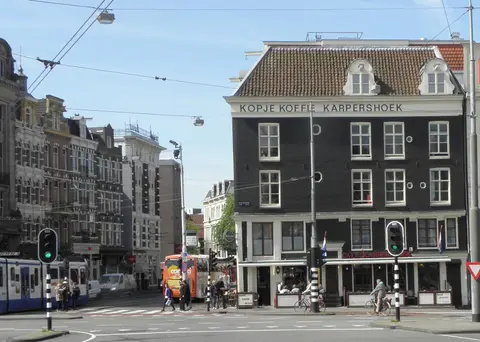 Dark corner building lettered Kopje Koffie Karpershoek above three floors, café awning below