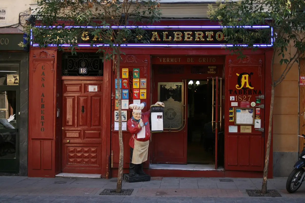 Red-painted taberna front, CASA ALBERTO in gold on the fascia and 1827 lettered beside the door