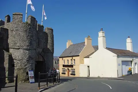 Castle Rushen's gatehouse on the left and the pub's cream front with its dark fascia to the right