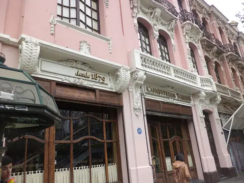 Gilt lettering reading desde 1879 and Confitería Torres on the white cornice of a pink front