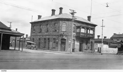 Black-and-white photograph of the two-storey stone Edinburgh Castle Hotel on the corner of Currie and Gray Streets, a 1920s car parked outside