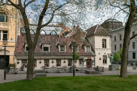 Low tiled-roof café on Bankplassen, its corner lettered anno 1857 Café, chairs out along the front