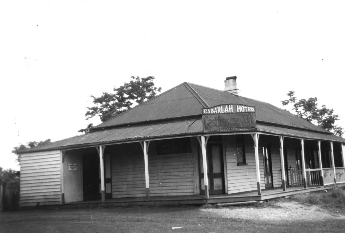 Black-and-white photograph of a single-storey weatherboard hotel with a hipped iron roof and verandah, its sign reading Cabarlah Hotel