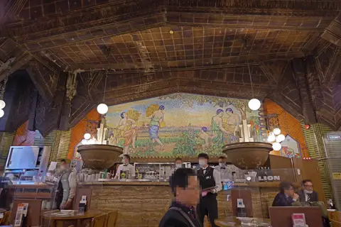 Beer hall with a glass mosaic of a barley harvest above the counter under a tiled, beamed ceiling