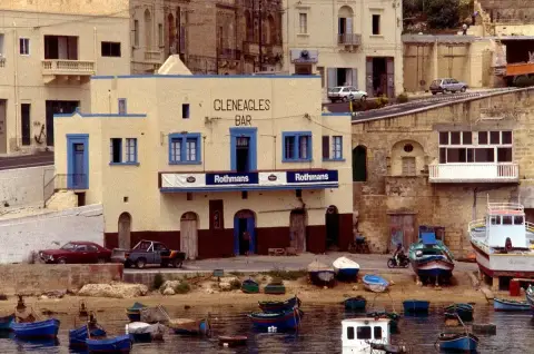 The Gleneagles Bar on the waterfront at Mġarr in 1989: a cream building with blue-framed windows and its name painted large, luzzu boats in front