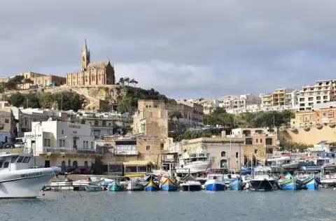 Mġarr harbour in 2019 with the white Gleneagles Bar on the waterfront at left, below the Lourdes church on the hill