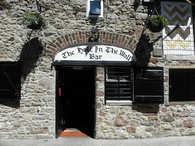 The stone front of the Hole in the Wall Bar, Armagh, its name painted on an arched board