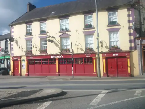 Cream-rendered two-storey pub with purple window surrounds and a long red front lettered Holohan’s, Lounge and Bar, on Slaney Place