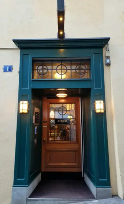 Green-painted doorcase at Pfalzgasse 1, KINDLI HOTEL lettered on the glass of the inner door