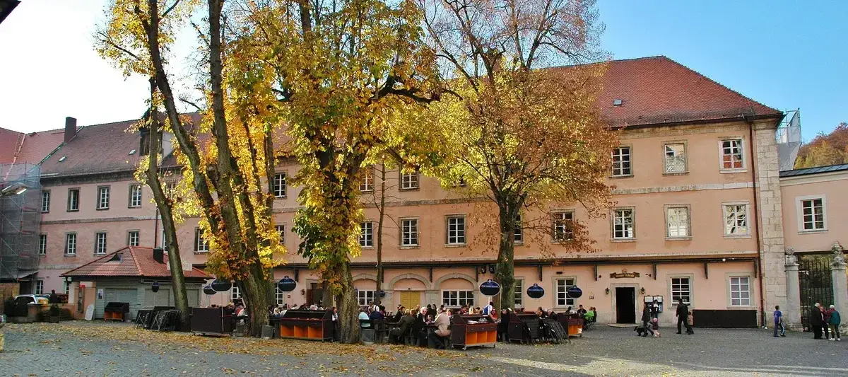 The long pink abbey range at Weltenburg, with the Klosterschenke’s tables and benches under autumn chestnuts