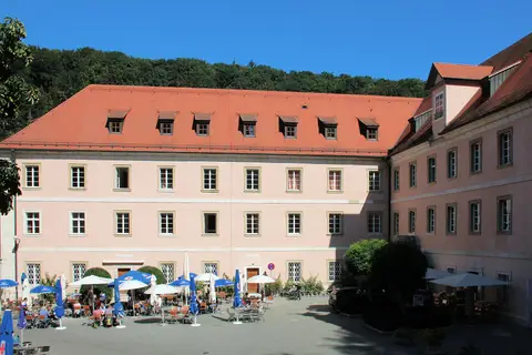 Weltenburg abbey courtyard in sunshine, with the Klosterschenke’s blue parasols and beer-garden tables