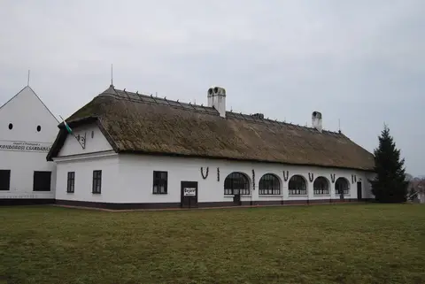 Thatched inn from the end, strings of paprika hung between arched windows and a Bejárat sign