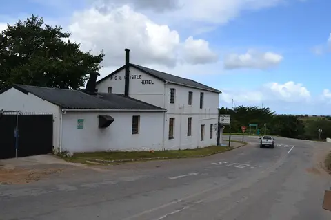 Pig and Whistle Hotel painted on the gable end of a whitewashed inn above a road junction