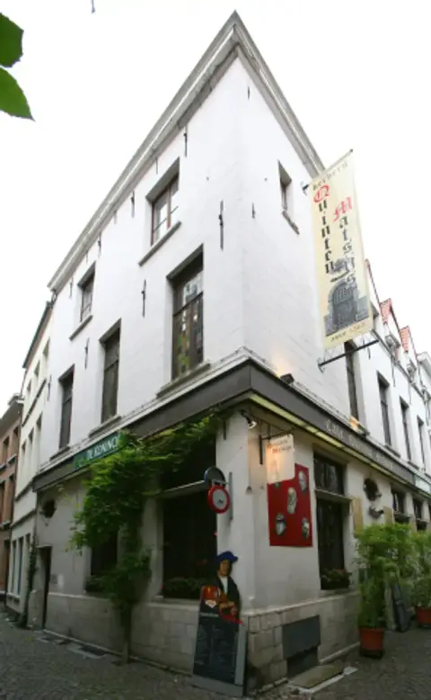 The white corner house of Quinten Matsijs on the Moriaanstraat, with a banner reading herberg Quinten Matsijs anno 1565 and ivy over the door