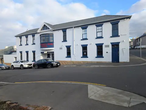 The whitewashed two-storey Shipwrights Arms Hotel on its Battery Point corner, with navy window hoods and a gabled bay window