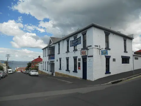 The Shipwrights Arms from the corner, both white street fronts visible with hanging signs and the Derwent down the hill