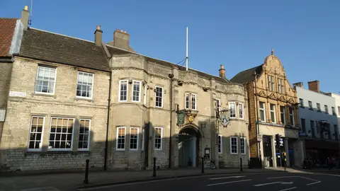 The inn on the High Street, its long stone front beside a taller stone and brick building