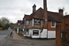 Hung-tile inn at a bend in the village street, board reading Pub Restaurant Riverside Gardens