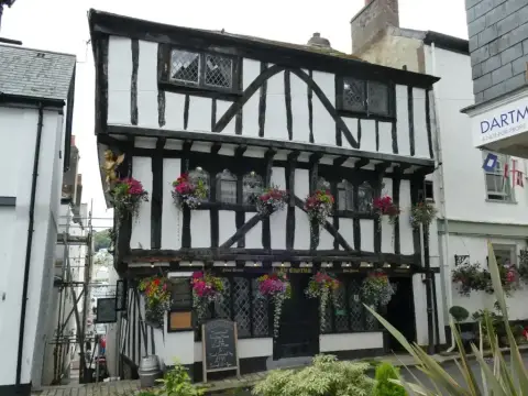 The same jettied timber inn seen from lower down Higher Street, flowers along both jetties