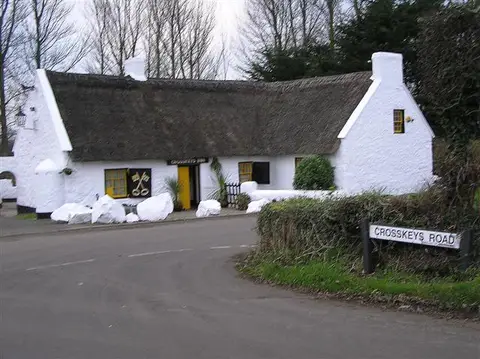 The thatched, whitewashed Crosskeys Inn with its name over the door and a crossed-keys sign