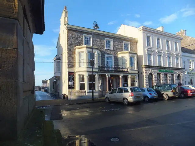 Three-storey stone hotel on the Parade with bay windows and a first-floor balcony on painted columns