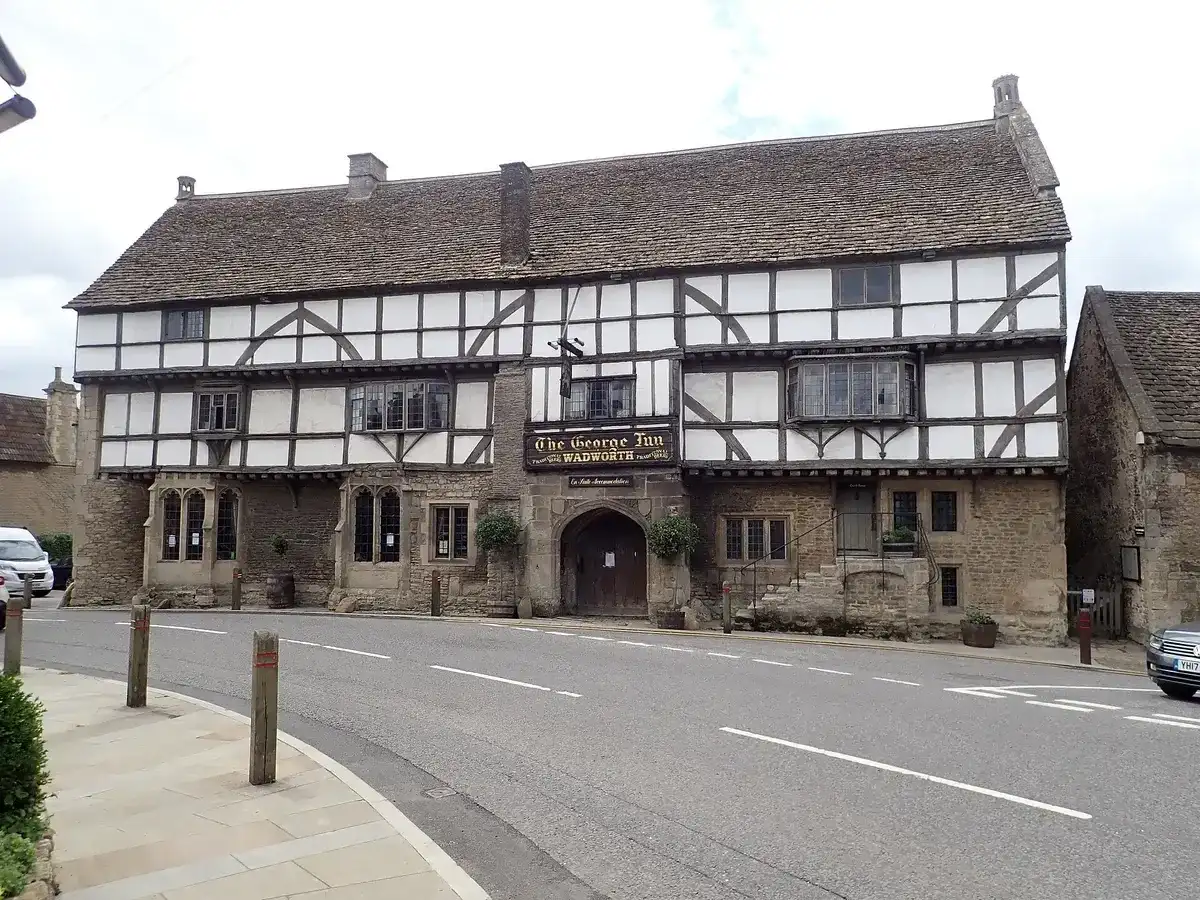 The George Inn at Norton St Philip: stone ground floor, timber-framed upper storeys and a wide arched entry