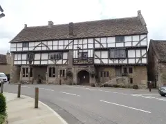 The George Inn at Norton St Philip: stone ground floor, timber-framed upper storeys and a wide arched entry