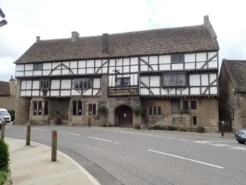 The George Inn at Norton St Philip: stone ground floor, timber-framed upper storeys and a wide arched entry