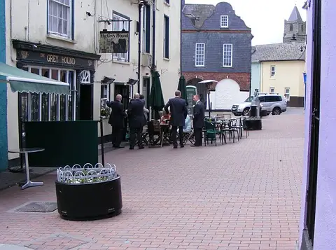Cream and black pub front lettered The Grey Hound, with tables outside on Kinsale's Market Square