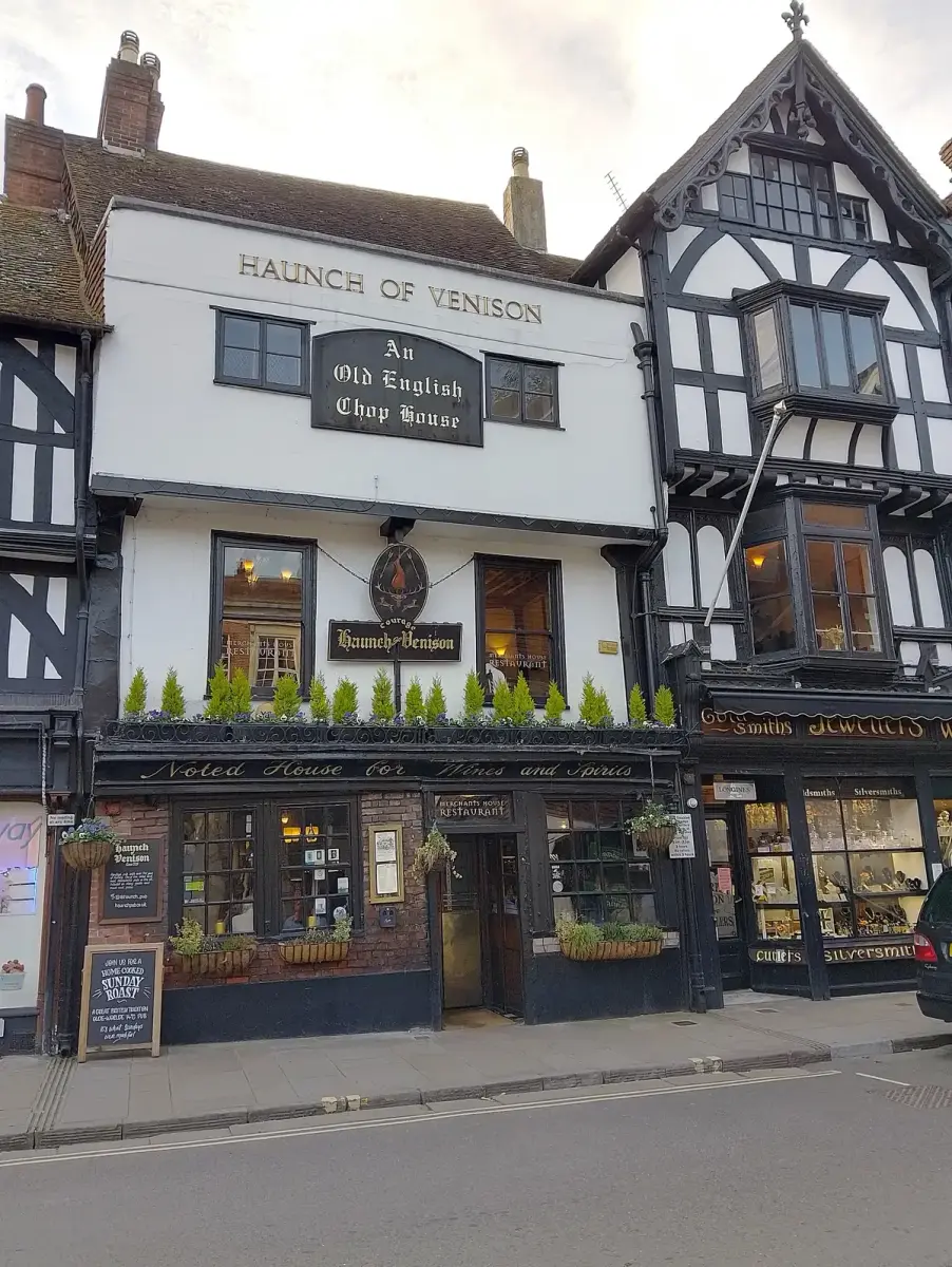 White-painted three-storey front lettered Haunch of Venison above a board reading An Old English Chop House