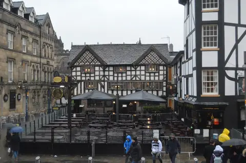 The Old Wellington's black-and-white timber front in Shambles Square, with tables and umbrellas outside