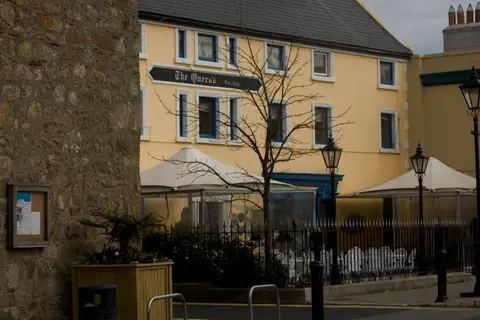 The Castle Street front in 2007: yellow frontage with an Est. 1745 board over the windows, canopies and pavement railings