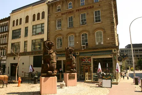 The sandstone Historic Properties building on Granville Street, with the Split Crow's green awning and crow sign on the ground floor behind two carved lions