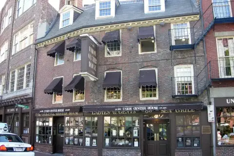 Brick front with brown awnings and a hanging board lettered ye olde Union Oyster House est. 1826