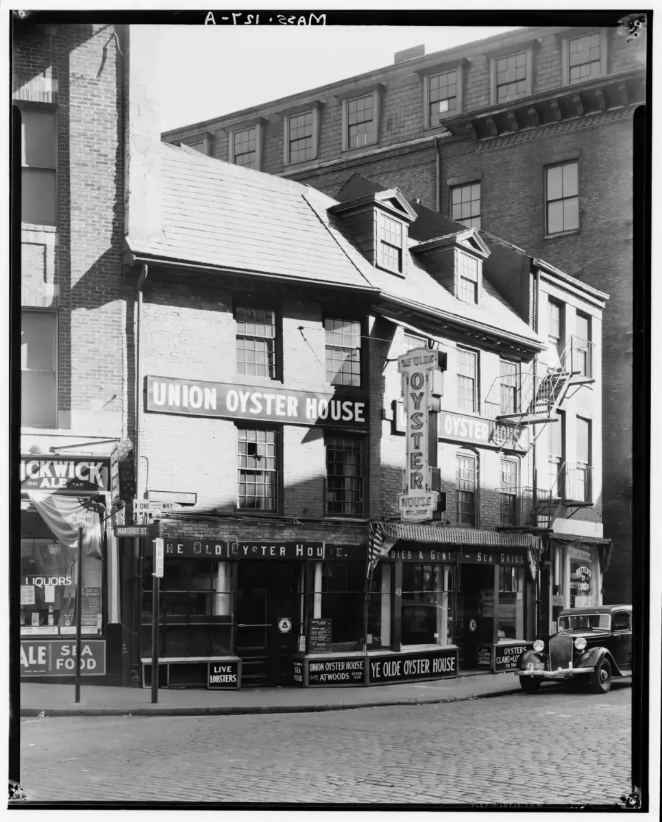 Black-and-white survey photograph of the Union Oyster House at the corner of Marshall Street, its painted signs and gambrel roof, a 1930s car at the kerb