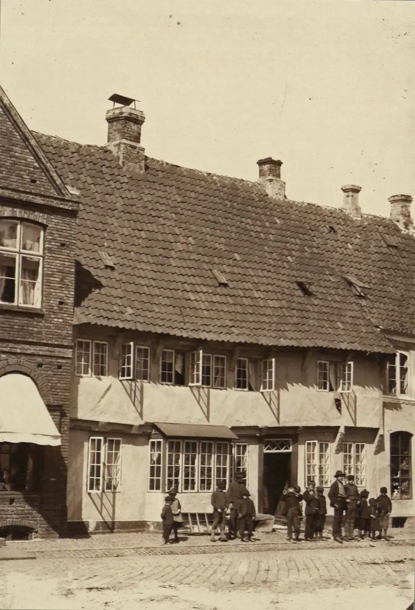 Black-and-white photograph of Weis Stue on the Torvet at Ribe in 1898, its frame then rendered and limewashed, with children outside
