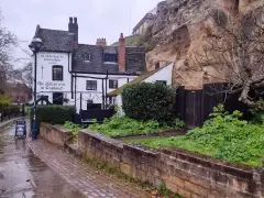 Ye Olde Trip to Jerusalem under the sandstone of Castle Rock, its gable painted 'the oldest inn in England'
