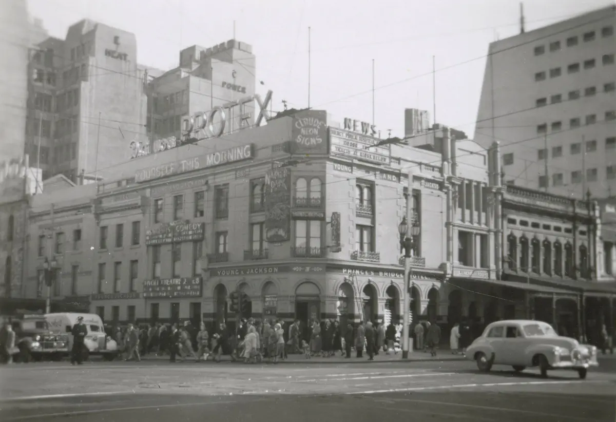 Young and Jackson on the Flinders Street corner about 1950, neon signs on the roof and a crowd at the crossing